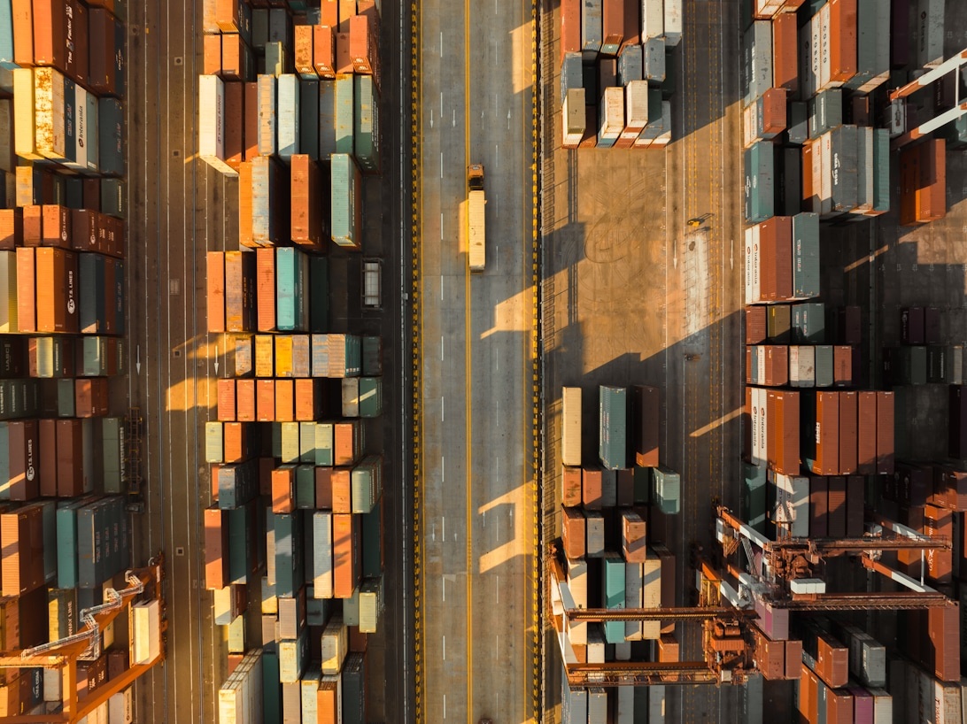 Flygvy över en stor containerhamn som visar storskalig logistikoptimering och drift.