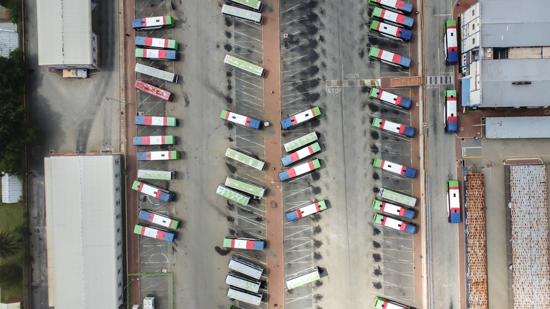 Flygvy över en logistikanläggning med systematiskt parkerade lastbilar.